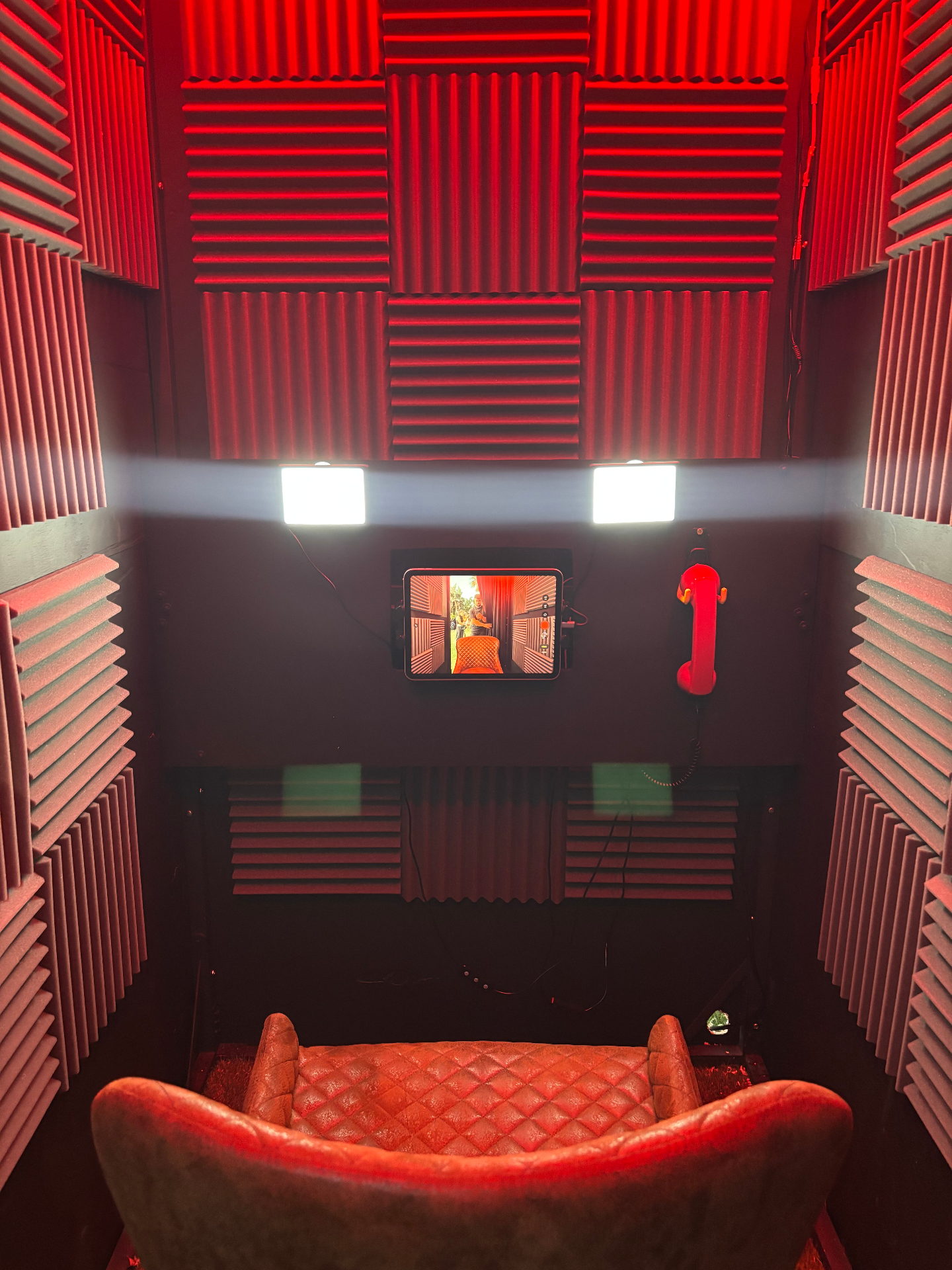 Detalle del interior del videoconfesionario con teléfono rojo